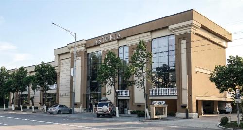a building on a street with cars parked in front at ASTORIA Boutique Hotel in Bălţi