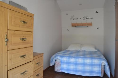 um pequeno quarto com uma cama e uma cómoda em Les Rossignal em Villiers-le-Roux