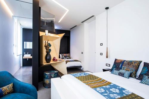 1 dormitorio con 1 cama blanca y 1 sofá azul en Villa Vi en Flumini di Quartu