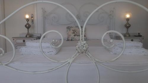 białe łóżko z białą pościelą i poduszkami w obiekcie Estate Dafnopanagia Luxury Apartment Ourania w mieście Kariá