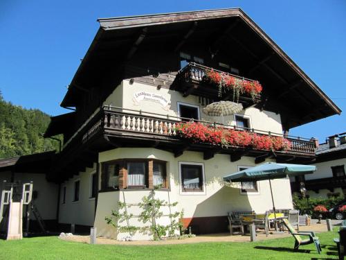 a building with a balcony with flowers on it at Apartments Landhaus Sonnheim in Lofer