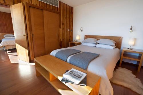 a bedroom with a large bed and a table at Hotel Antumalal in Pucón