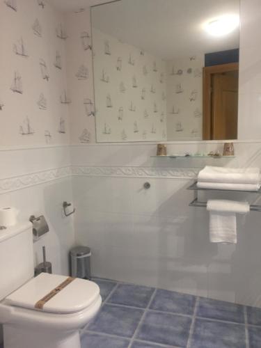 biała łazienka z toaletą i umywalką w obiekcie Portosín -Suites w mieście Portosin