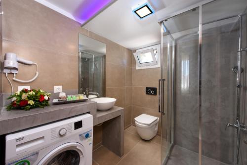 uma casa de banho com uma máquina de lavar roupa e um chuveiro em Angelo Del'Arte Estate em Corfu Town