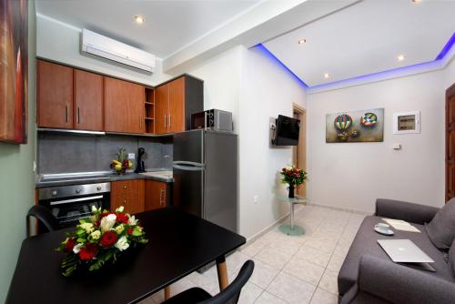 a kitchen and a living room with a table with flowers on it at Angelo Del'Arte Estate in Corfu Town