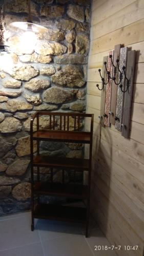 a room with a stone wall and a wooden shelf at Villa Haris in Sarti