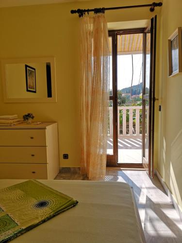 a bedroom with a bed and a sliding glass door at Apartments and Rooms Villa Mir in Zaton