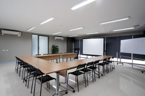 a conference room with a long table and chairs at ONPA Hotel & Residence Bangsaen in Bangsaen