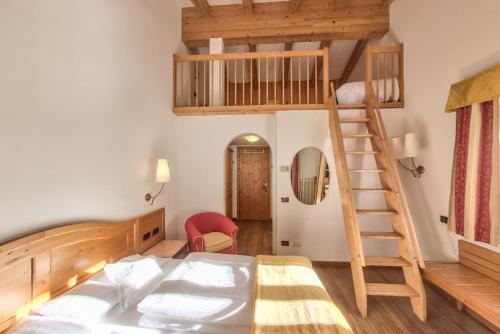 een slaapkamer met een stapelbed en een ladder bij Hotel Alpino Al Cavalletto in Canazei