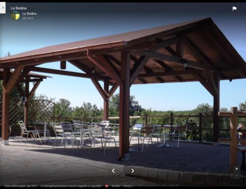 a large wooden pavilion with chairs and tables at La Bedina in Rivara