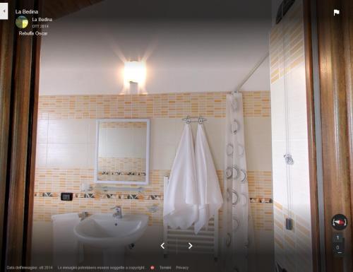 a bathroom with a sink and a shower with a light at La Bedina in Rivara