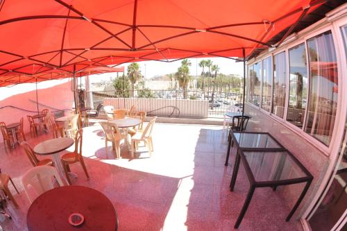 a patio with tables and chairs under an orange umbrella at Palm Hostel in Jerusalem