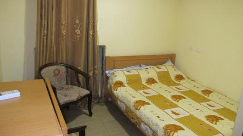 a bedroom with a bed and a table and a chair at Palm Hostel in Jerusalem