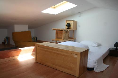 - une chambre avec un lit, un canapé et une lucarne dans l'établissement Maison les Salles-sur-Verdon, aux Salles-sur-Verdon