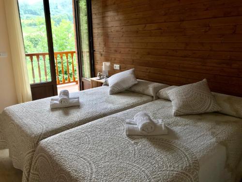 Dos camas en una habitación con dos toallas. en Alojamiento Rural Cosorios en Cangas de Onís