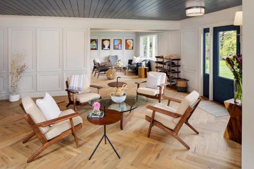 a living room with chairs and a table at Journey East Hampton in East Hampton