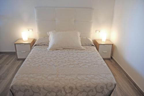 フエンヒロラにあるRecently refurbished apartment with sea views.のベッドルームに大型ベッド1台(ナイトスタンド2台付)が備わります。