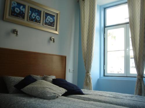 a bedroom with a bed with a large window at Baixainn in Lisbon