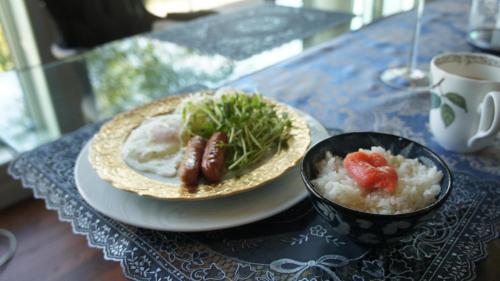 a plate with two hot dogs and a bowl of rice at Joy House in Imari