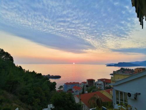 a view of the ocean from a city at sunset at Apartmani Famelja Jovanovic in Sveti Stefan