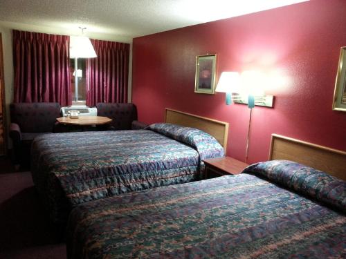 um quarto de hotel com duas camas e paredes vermelhas em Willow Springs Motel em Cheney