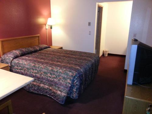 a hotel room with a bed and a television at Willow Springs Motel in Cheney