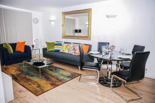 een woonkamer met een bank en een tafel bij RIVERSIDE 2 BED APARTMENT in North Woolwich