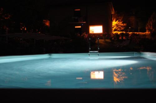 a swimming pool at night with a fire in the background at Amata Valgre Affittacamere, comfort e pulizia eccezionali!! in Olginate