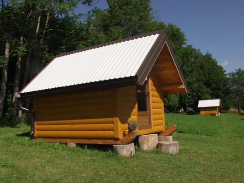a small cabin with a tin roof on a field at Tara Place - Camp Rabrenovic in Mojkovac