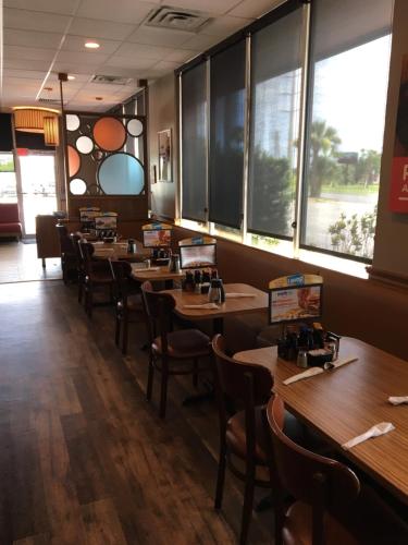 a row of tables and chairs in a restaurant at Days Inn by Wyndham Titusville Kennedy Space Center in Titusville