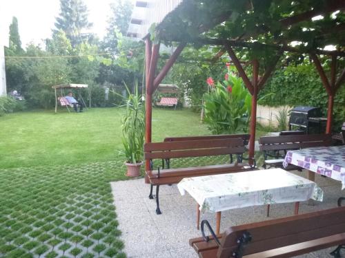 two benches and a picnic table in a yard at Apartmanovy dom Grand in Štúrovo