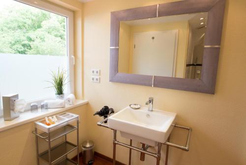 a bathroom with a sink and a mirror on the wall at Villa Godewind in Travemünde