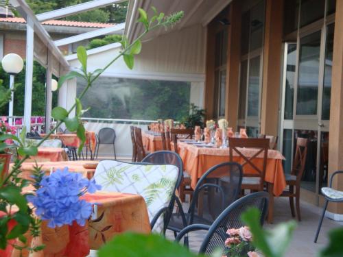 a dining room with tables and chairs and a patio at Hotel Garden Ristorante in Tabiano