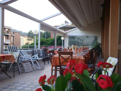 a restaurant patio with tables and chairs and windows at Hotel Garden Ristorante in Tabiano