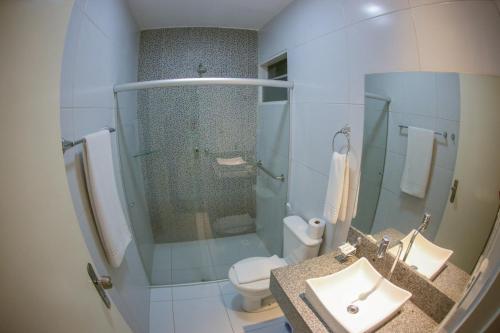 a bathroom with a toilet and a sink and a shower at Caruaru Park Hotel in Caruaru