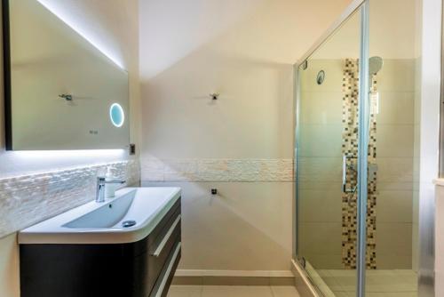 a bathroom with a sink and a shower at Le KatoBay Residence in Pereybere