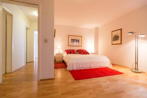 una camera con un letto e un tappeto rosso di Ferienwohnung Mittendrin a Bergisch Gladbach