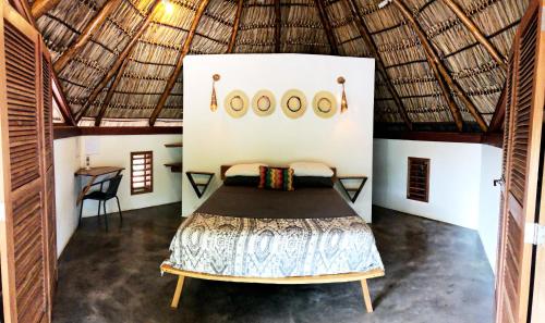 a bedroom with a bed in a straw hut at Casitas Pacific in Popoyo