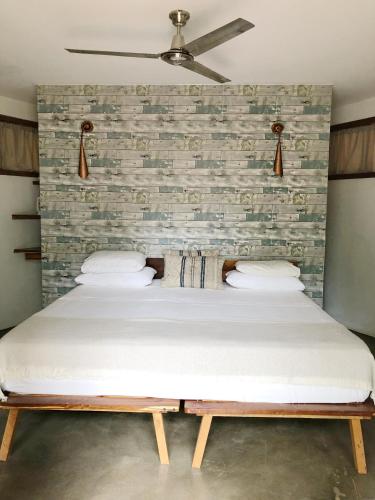 a bed in a room with a brick wall at Casitas Pacific in Popoyo