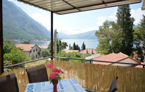 a balcony with a table and a view of a lake at B & M Apartments in Kotor
