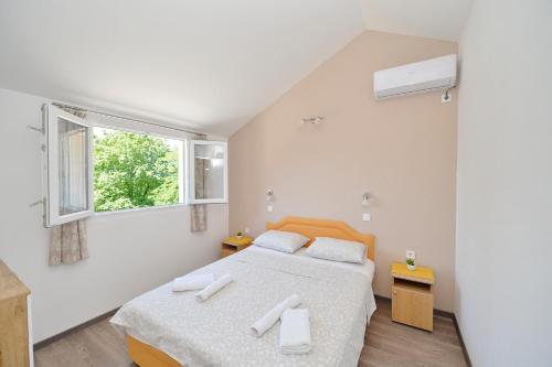 a bedroom with two beds and a window at B & M Apartments in Kotor
