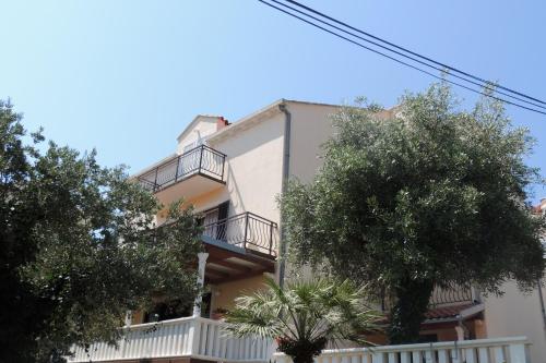 un edificio bianco con balconi e alberi di Oaza a Dubrovnik