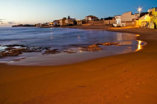 a view of a beach with the tide coming in at Lido Apartment in Donnalucata