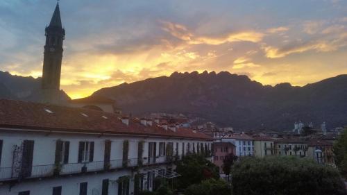 a view of a city with a clock tower at sunset at Casa al Lago in Lecco