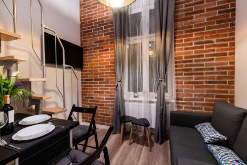 a room with a table and chairs and a brick wall at DIETLA 99 APARTMENTS - IDEAL LOCATION - in the heart of Krakow in Kraków