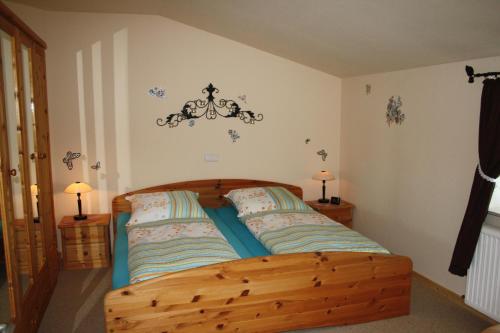 a bedroom with a wooden bed with a chandelier on the wall at " Haus zwischen den Meeren " in Strübbel