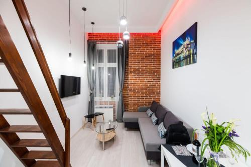 a living room with a couch and a brick wall at DIETLA 99 APARTMENTS - IDEAL LOCATION - in the heart of Krakow in Kraków