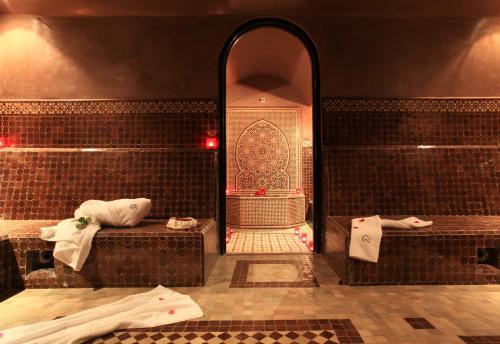 baño con paredes de azulejos marrones y espejo en Essaouira Lodge en Esauira