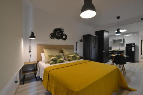 sypialnia z żółtym łóżkiem i kuchnią w obiekcie Loft Urban Casual w Alicante