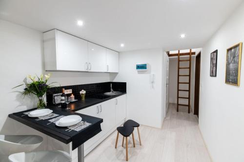 a kitchen with a black counter and white cabinets at DIETLA 99 APARTMENTS - IDEAL LOCATION - in the heart of Krakow in Kraków